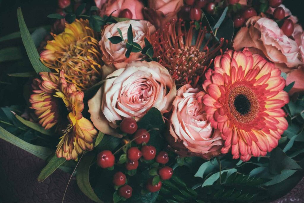 What are some other plants that pair well with Moses-in-the-Cradle in arrangements